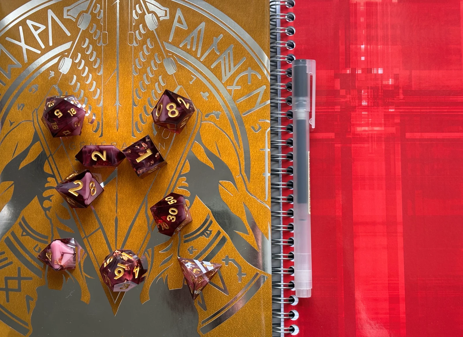 Jeu de dés de JDR posés sur un carnet pour une session de jeu de rôle solo, ambiance rouge et or.